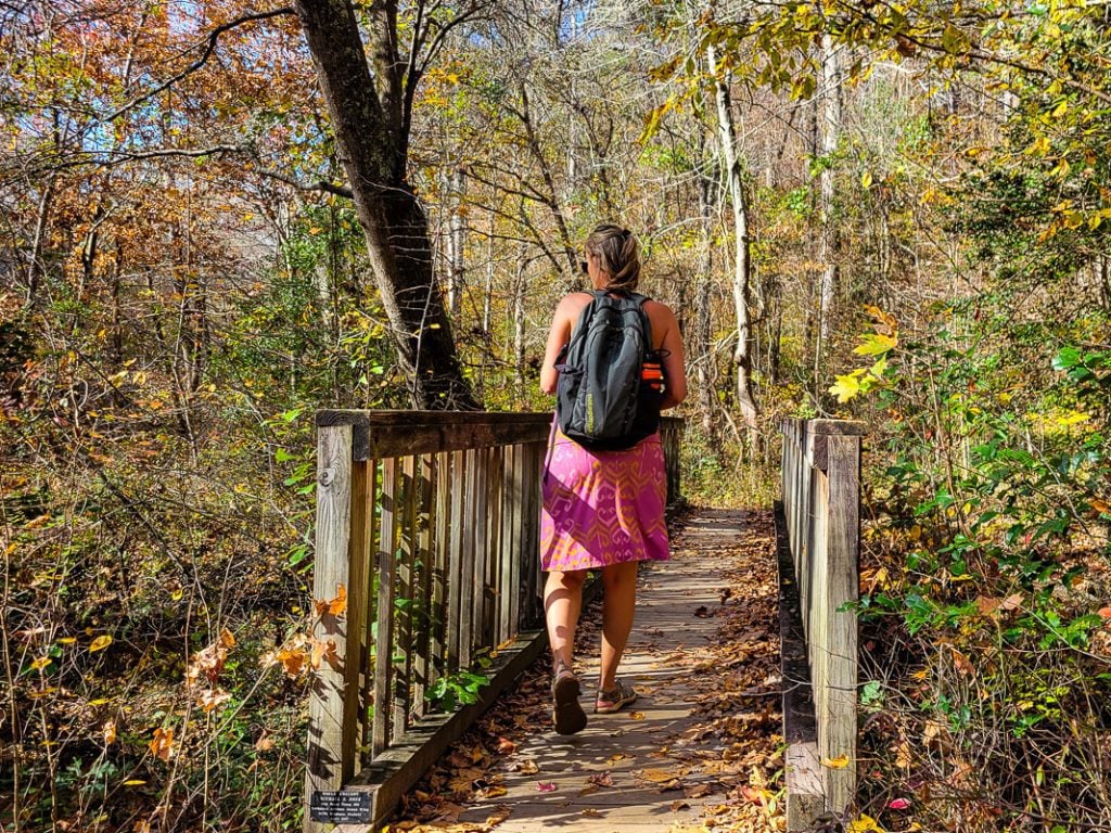 Woman walking across a wooden bridge