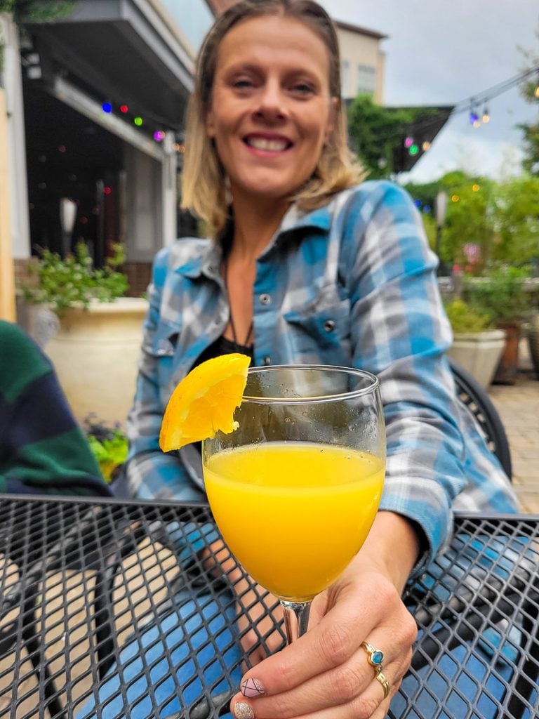 Lady holding mimosa cocktail in her hand