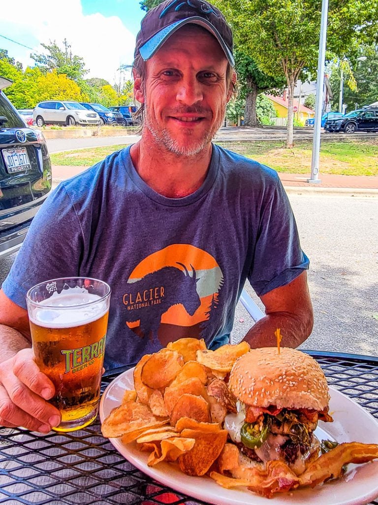 Man eating a burger and drinking beer