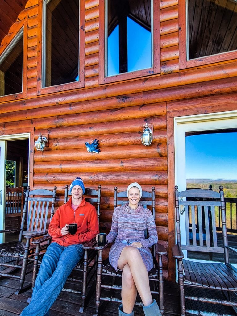 Husband and wife sitting on a deck of a cabin