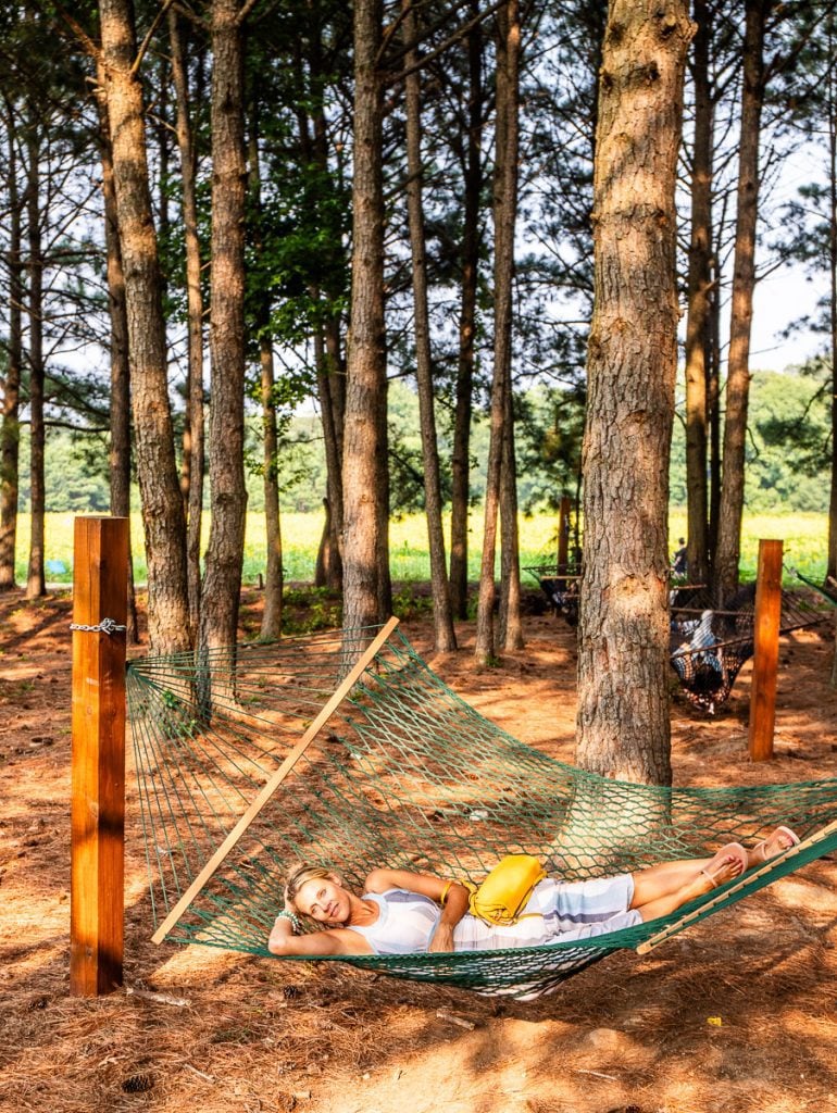 Lady swinging in a hammock under trees