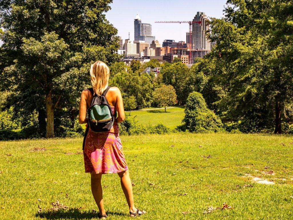 Lady looking at a city skyline from a park