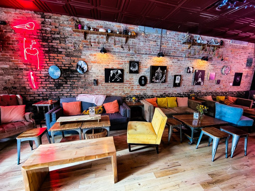 Couches, tables, and artwork on a wall in a bar