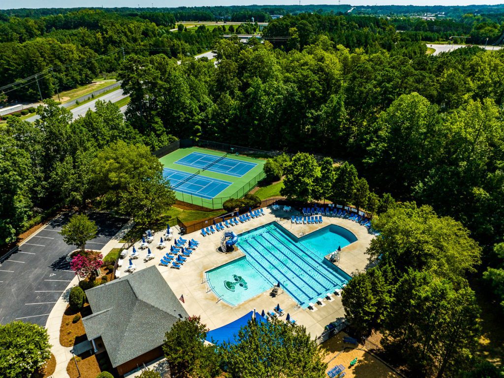 Aerial view of a pool and tennis courts