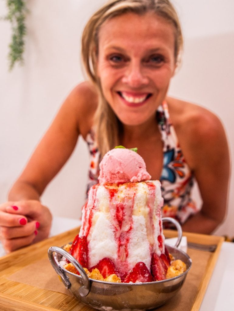 Woman eating a strawberry shaved ice dessert