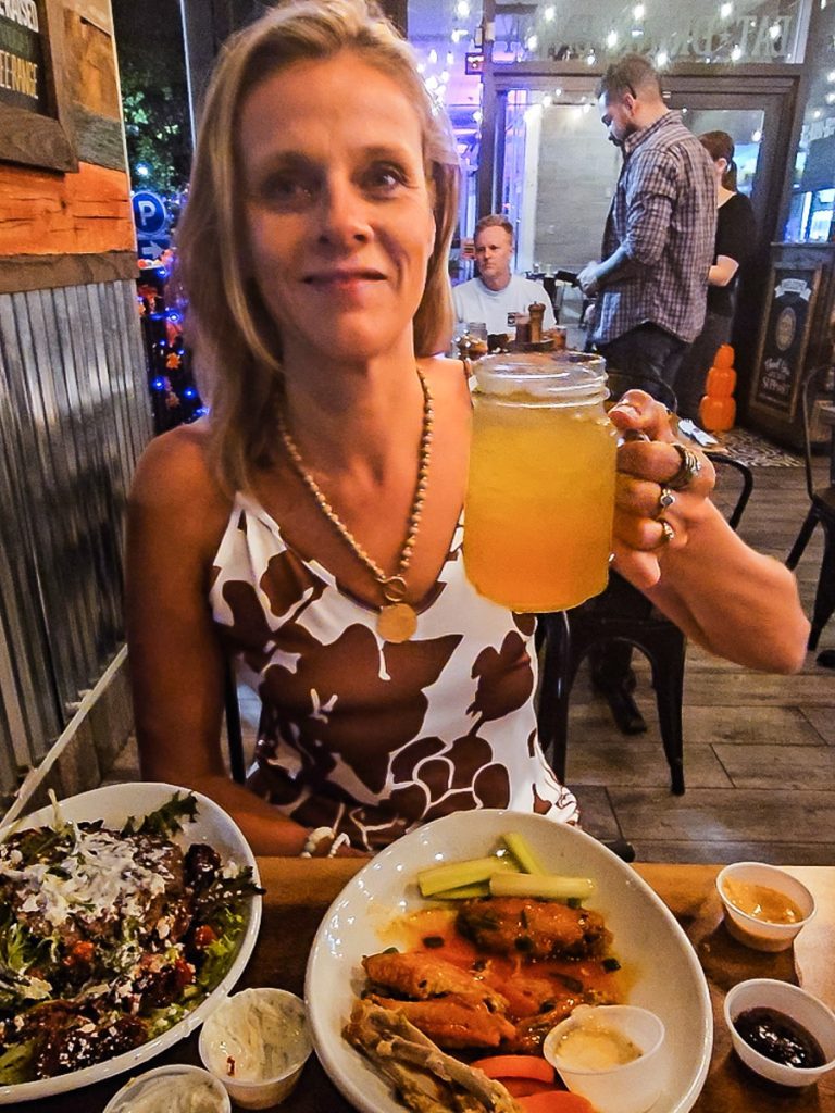 A lady holding up a drink at dinner.