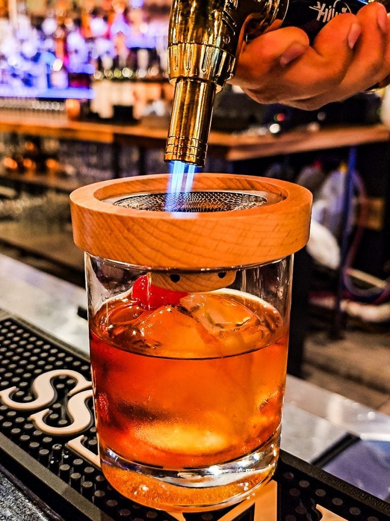 A cocktail glass with a flame.