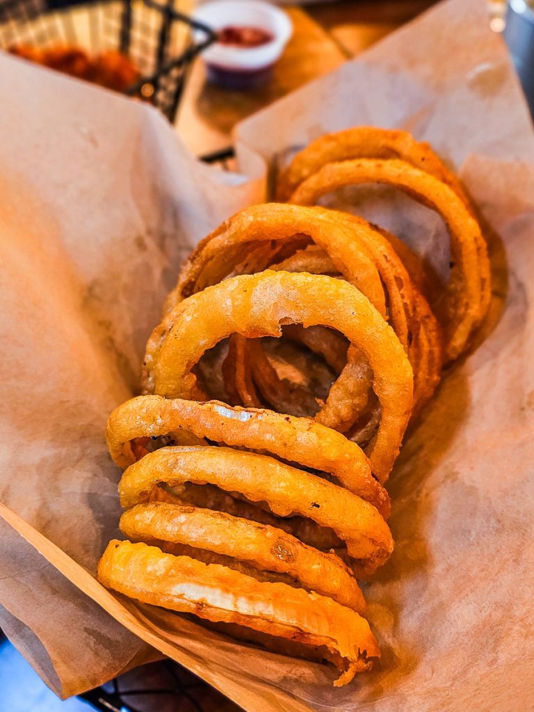 Basket of onion rings on paper.