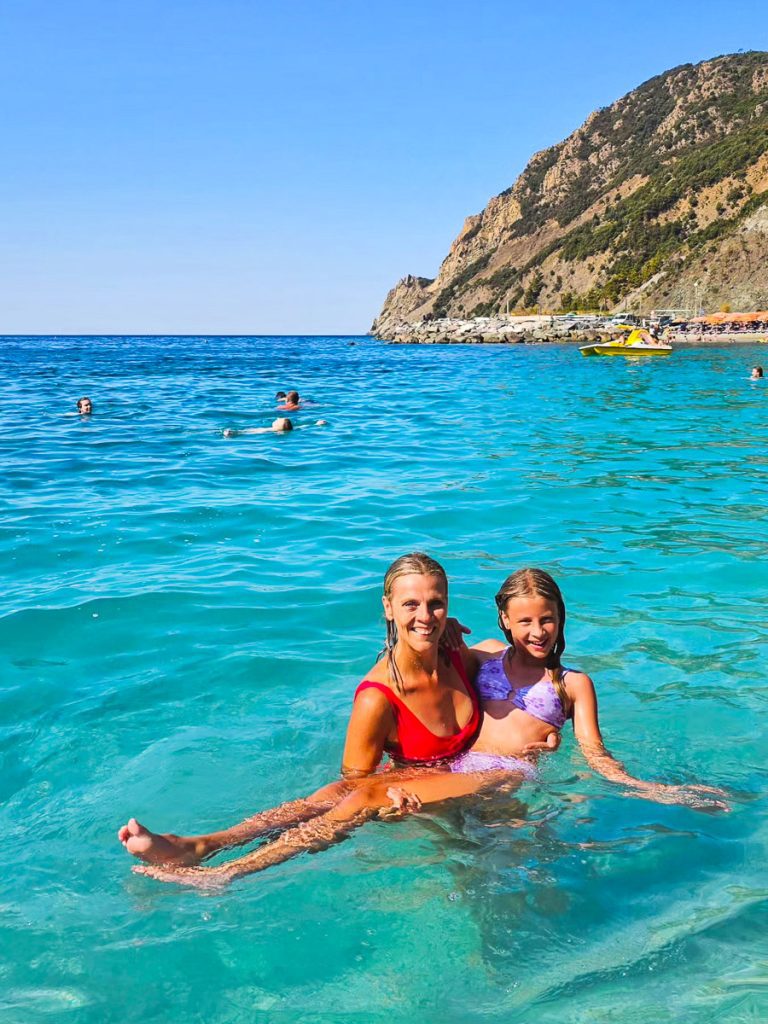 Mom and daughter swimming in the ocean in Italy