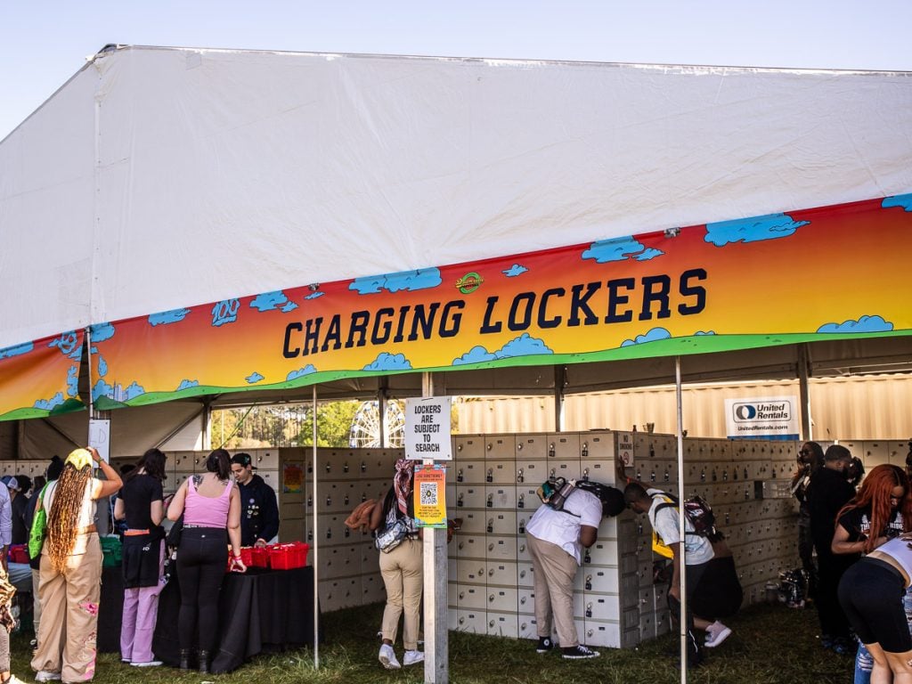 People at a music festival putting gear in lockers.