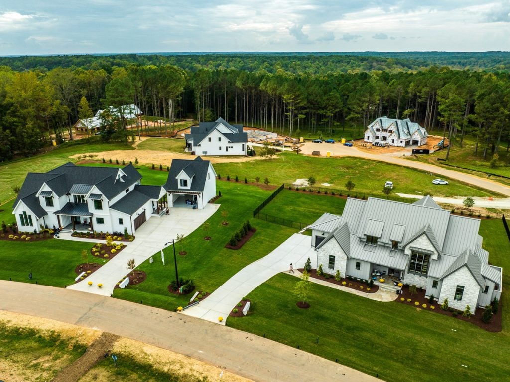 Aerial photo of houses in a neighborhood with green trees.