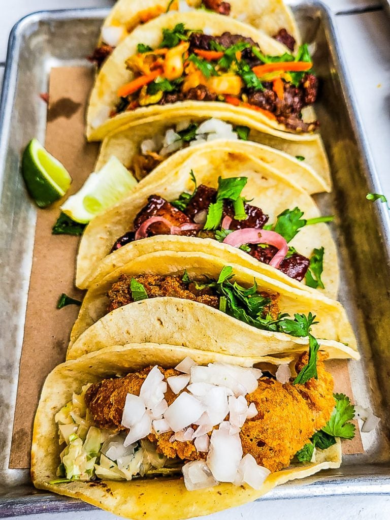 5 tacos on a tray.