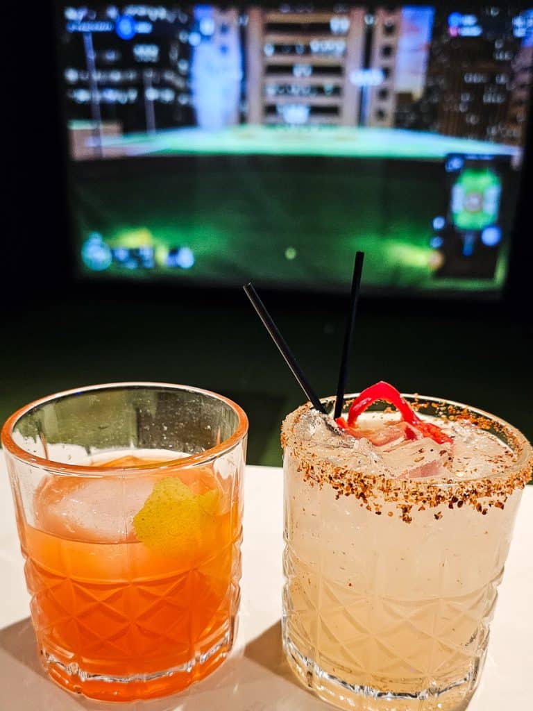 Two cocktails on a bar.