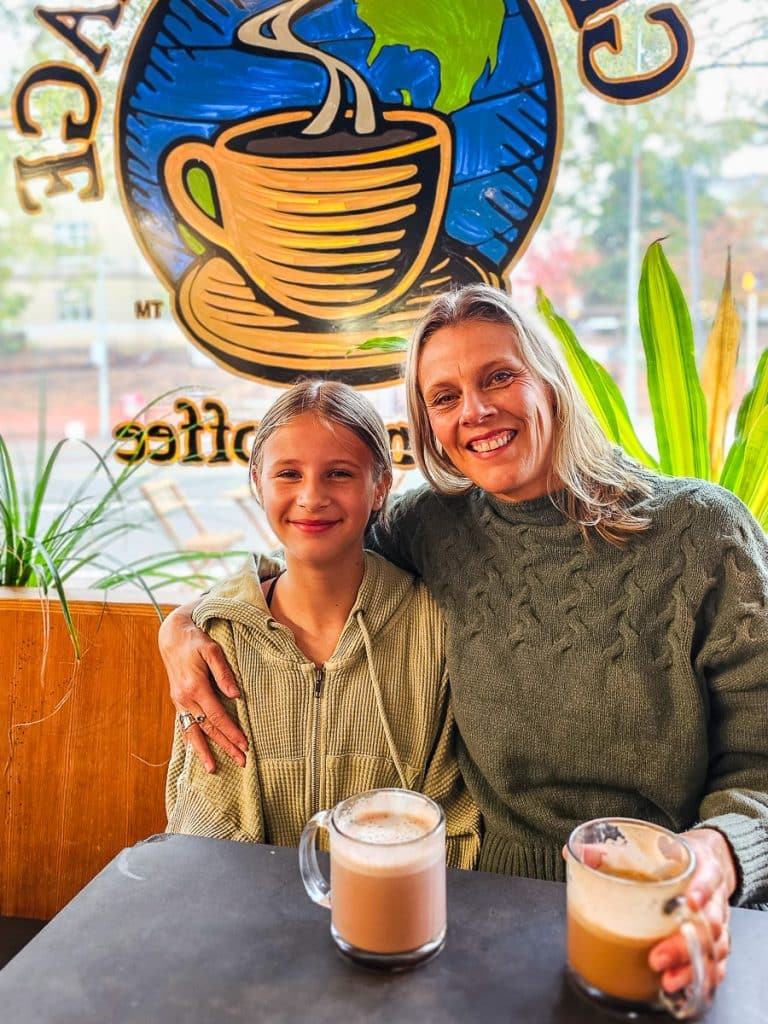 Mom and daughter drinking in a coffee shop.