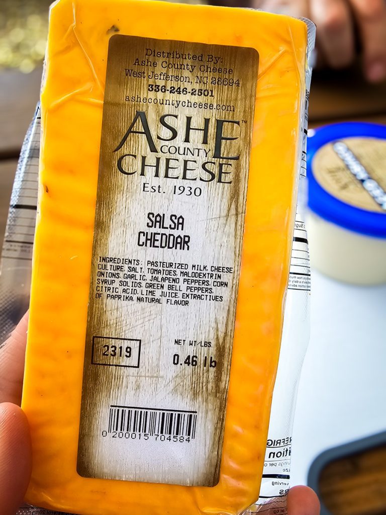 person holding block of ashe cheese