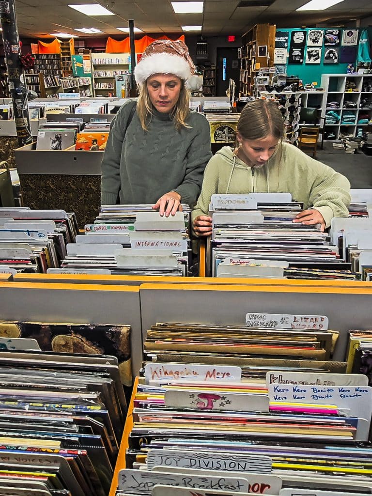 Mom and daughter looking at records in a store.