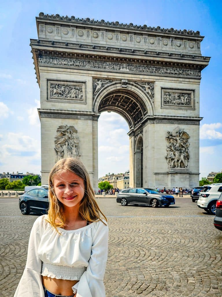 Girl in front of the Arc De Triomphe in Paris.