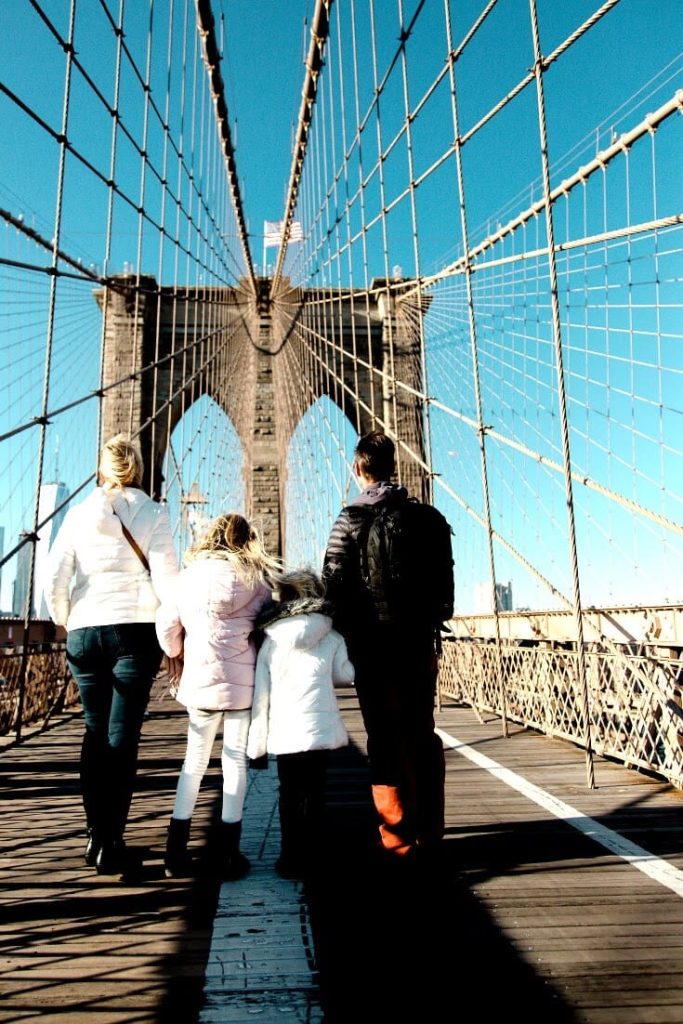 Family walking across the Brooklyn Bridge in NYC.