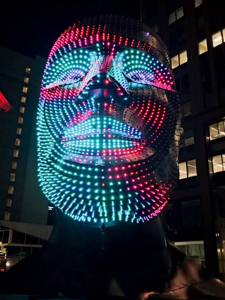 sculptured head illuminated by colored lights