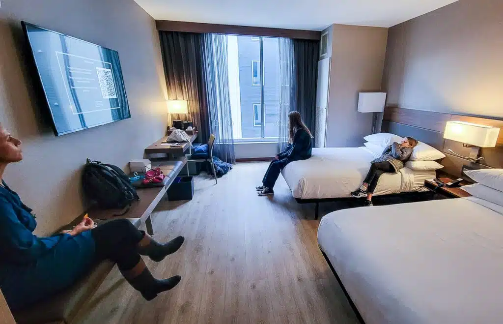 People lying on beds in a hotel room.
