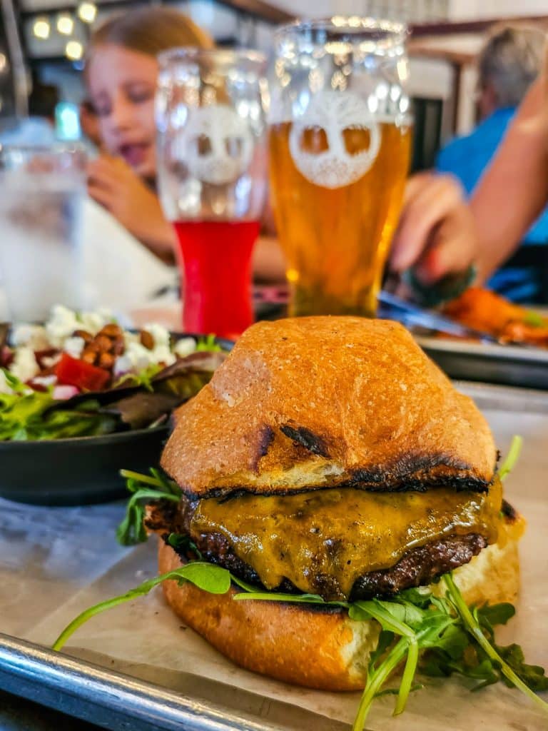 Burger with cheese and two glasses of beer.