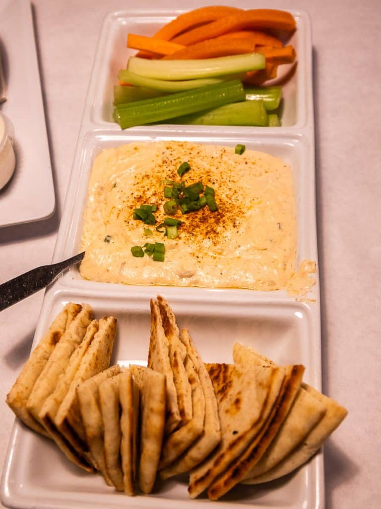 Dips and pita bread on a plate.
