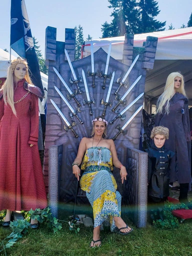lady sitting on game of throne display at ren fair