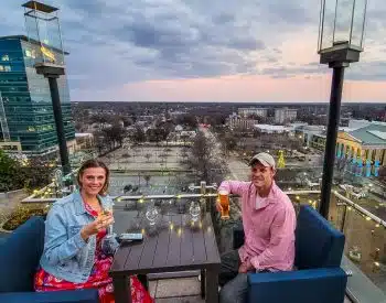 Man and women having a drink on a rooftop bar.