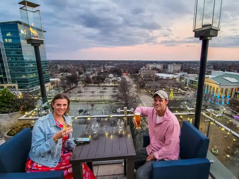 Man and women having a drink on a rooftop bar.