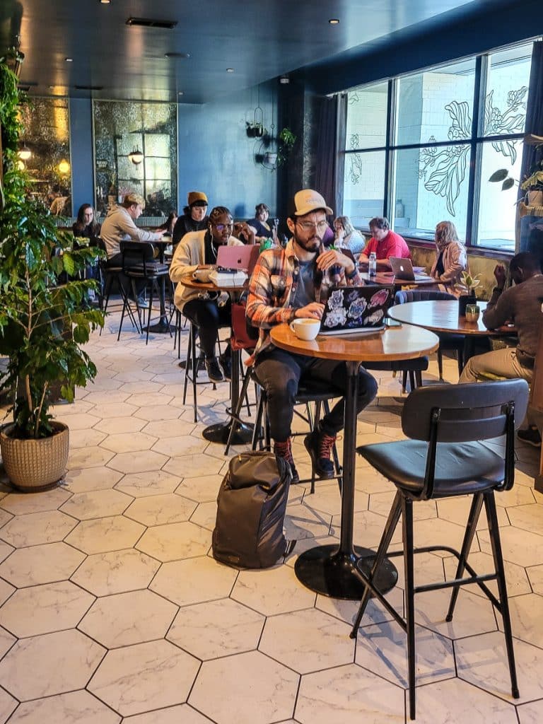 People sitting in a cafe at tables.