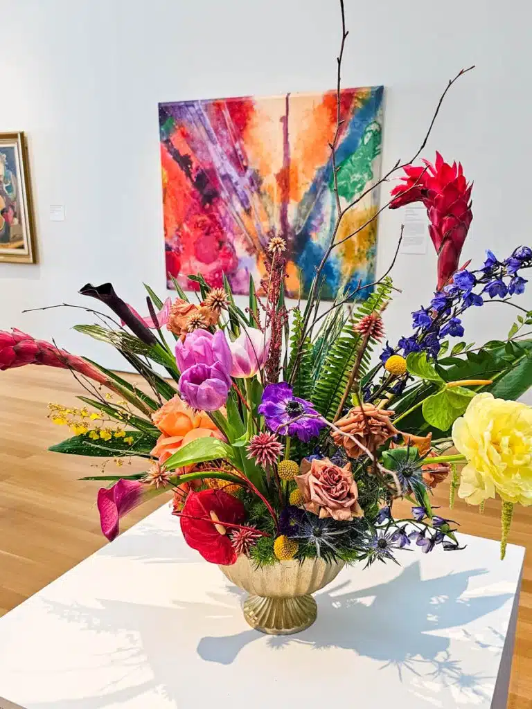 floral arrangement in front of painting in nc art museum