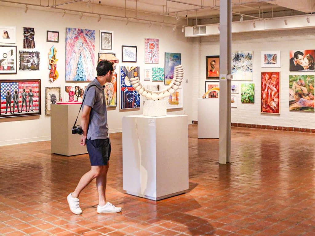 man looking at art in gallery