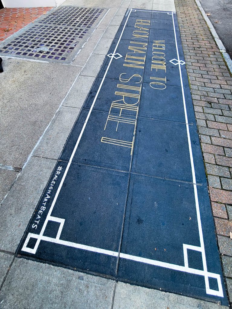 black main street raleigh sign on pavement