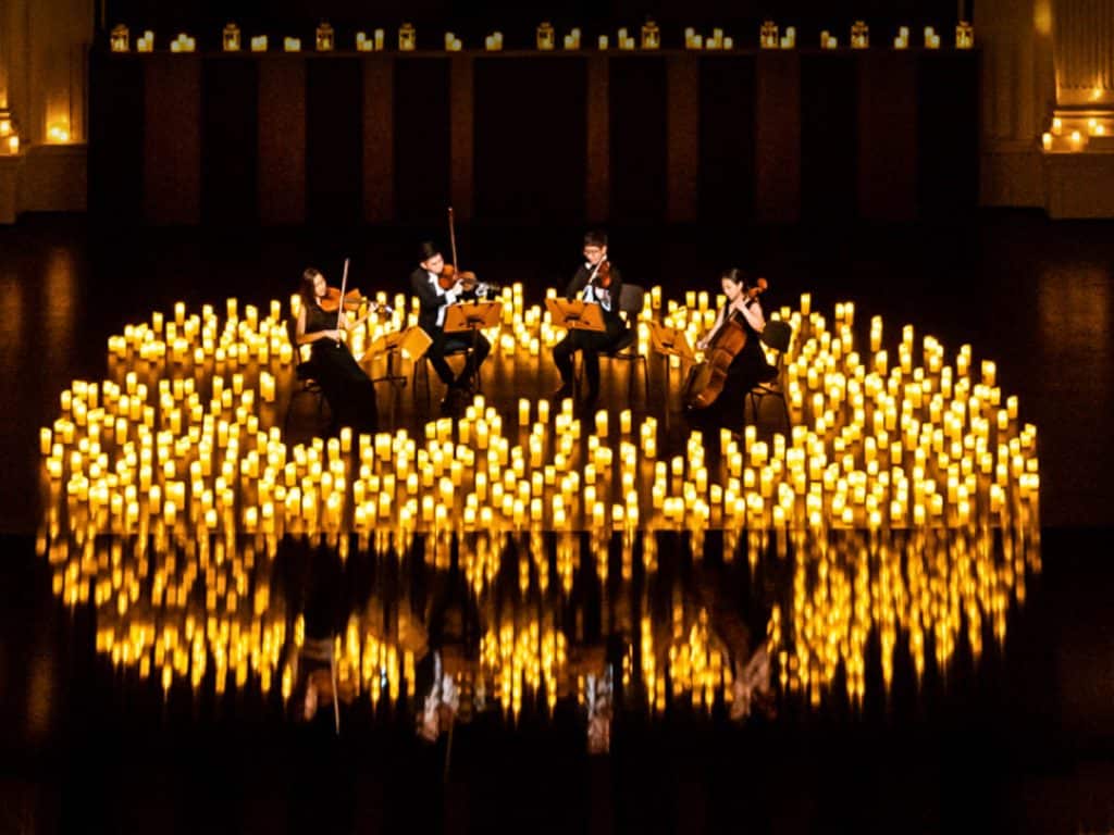 string quartet on stage surrounded by candles