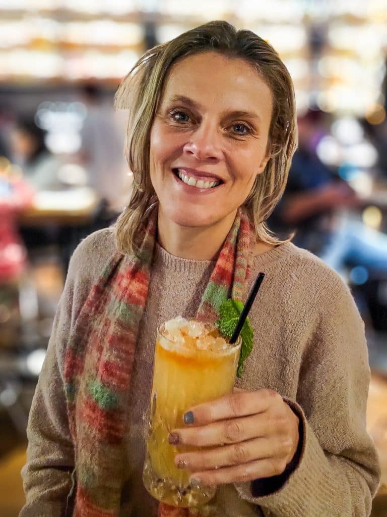 Lady holding up a cocktail glass.