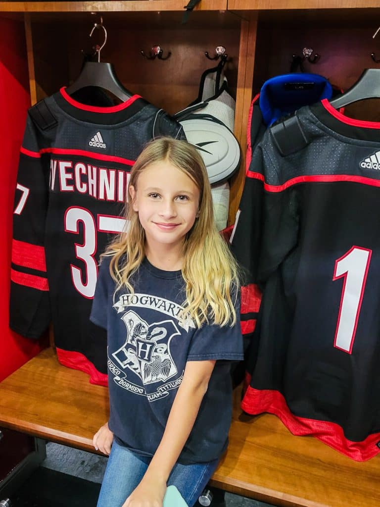 Young girl inside a locker room at a sports arena.