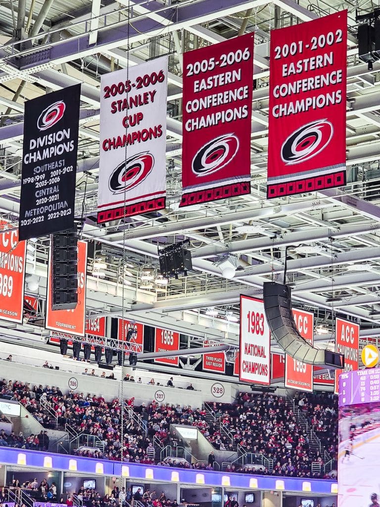 Banners hanging from the roof of a sports arena.