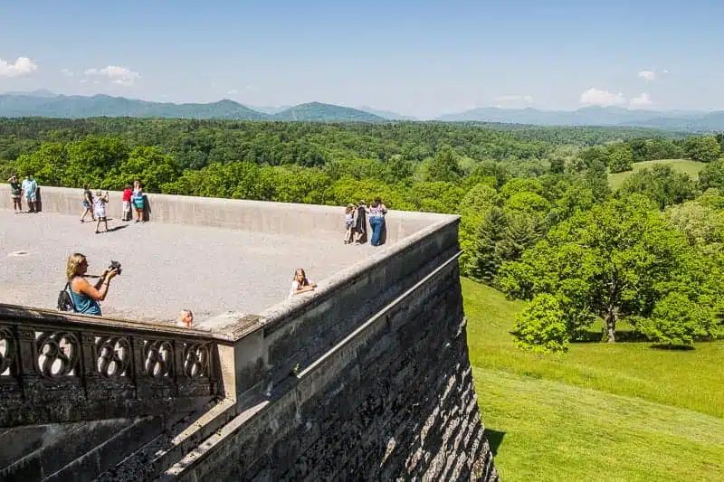 people standing on rooftop looking at pisgah forest