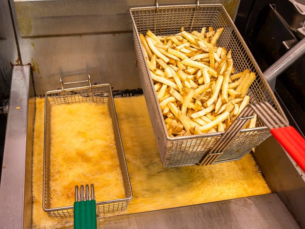 Fries getting cooked in a fryer.