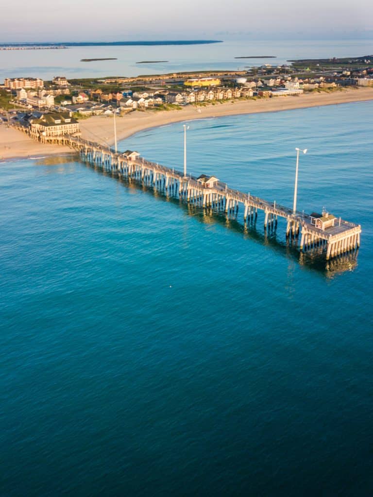A pier stretching into the ocean at a beach.