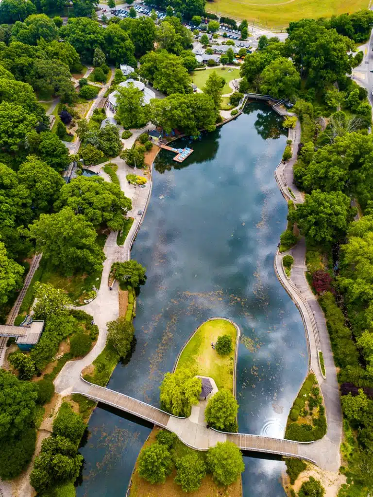 Aerial view of a park with trees and lake.
