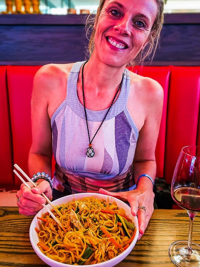 Woman eating a bowl of noodles.
