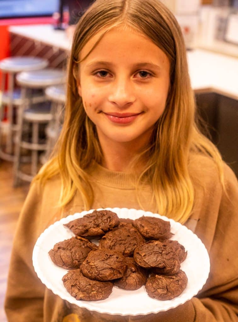Girl holding a plate of cookies.
