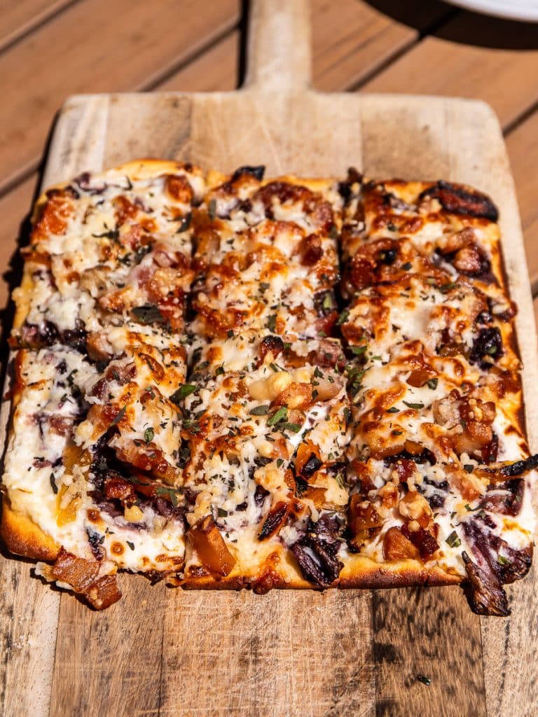 A flatbread pizza on a board.
