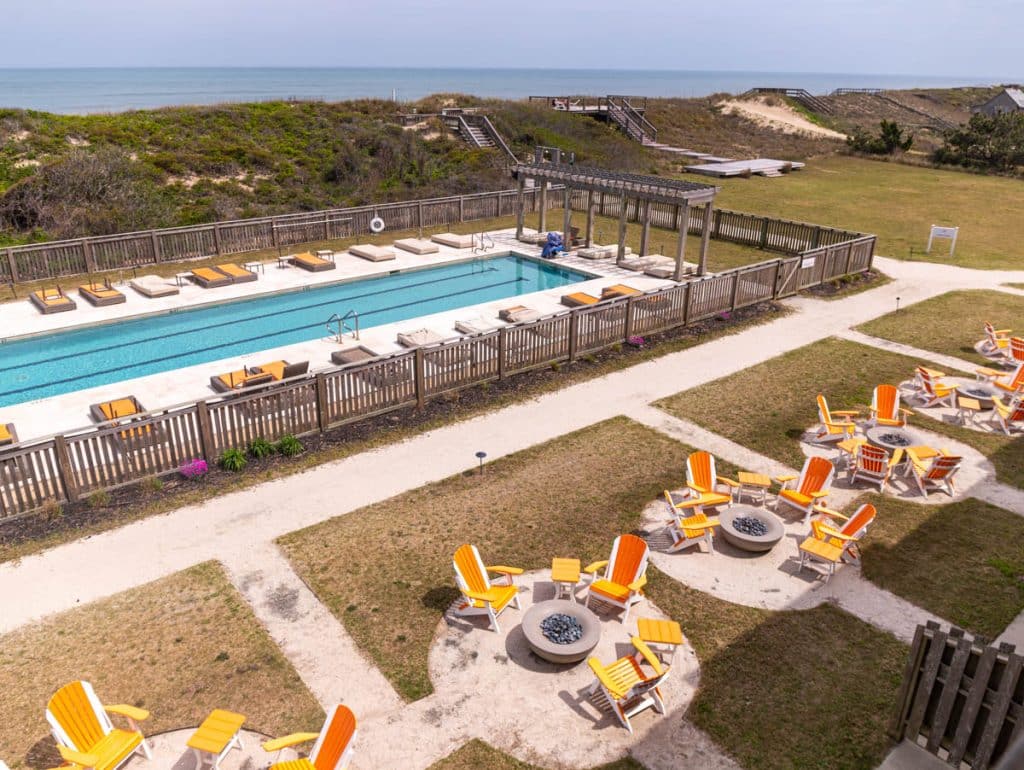 aerial view of firepits next to hotel pool with ocean views
