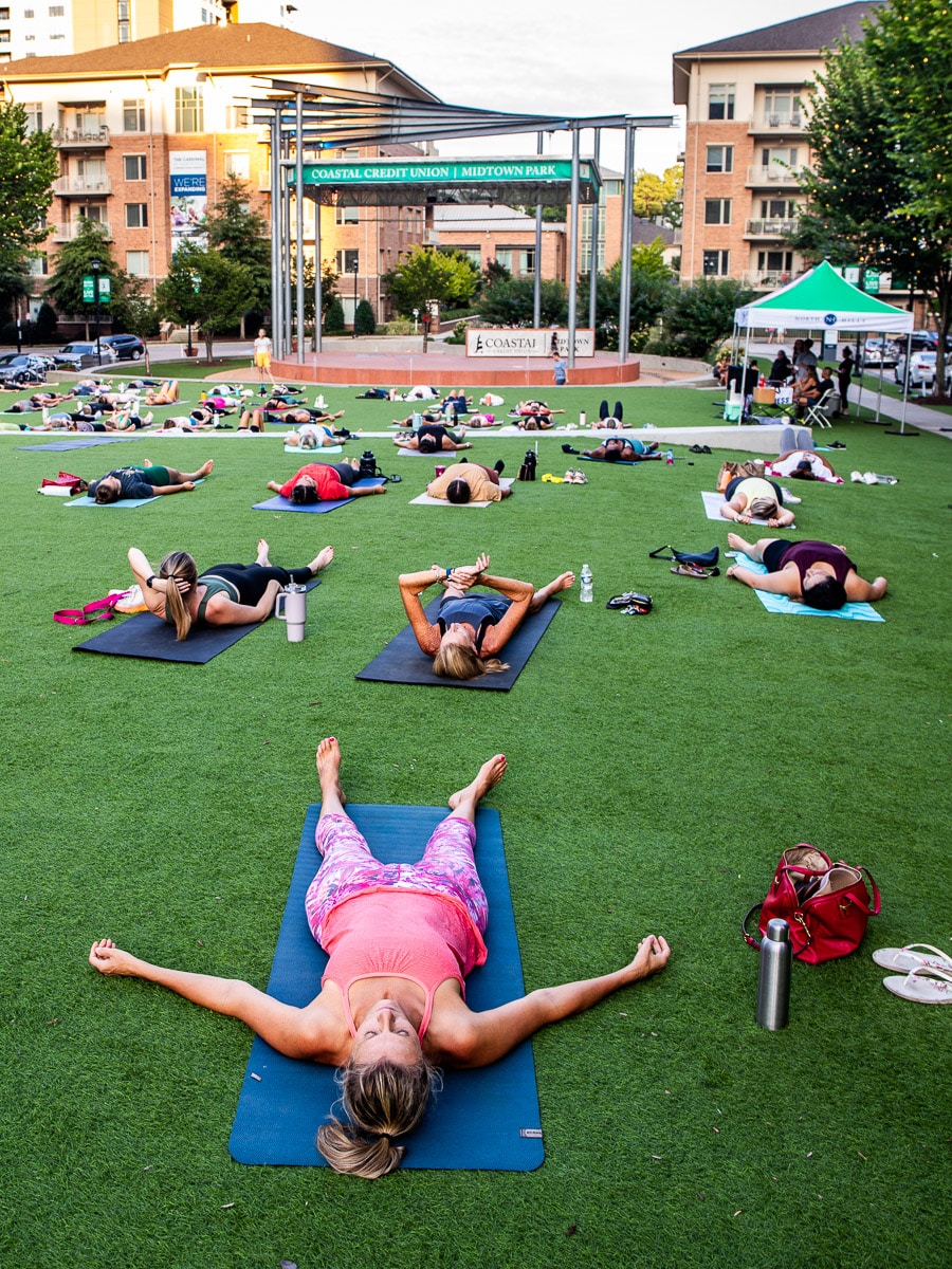 People doing yoga in a park.