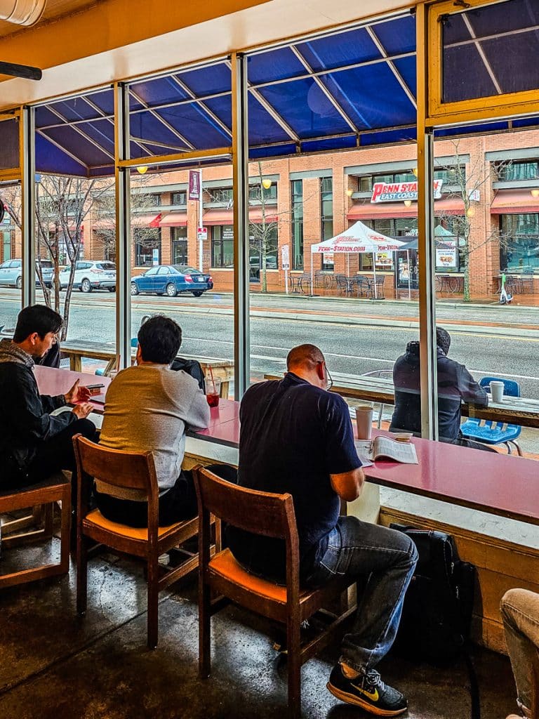 People sitting by a window drinking coffee.
