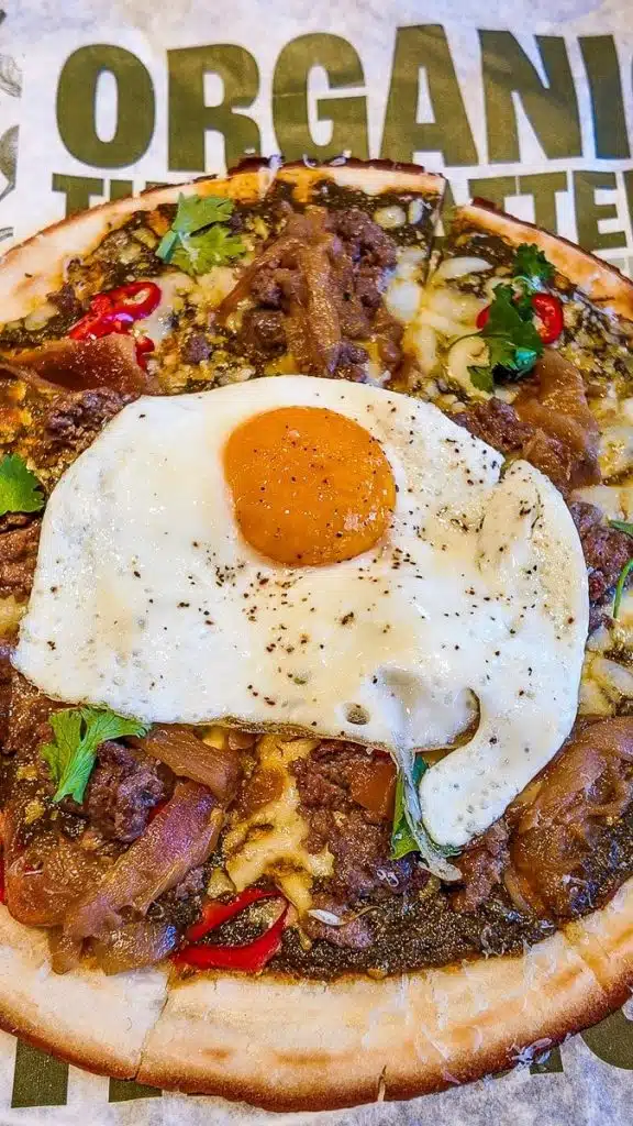 pizza with egg on top at true food kitchens