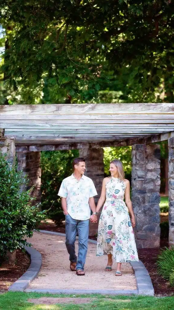 man and woman walking through rose garden
