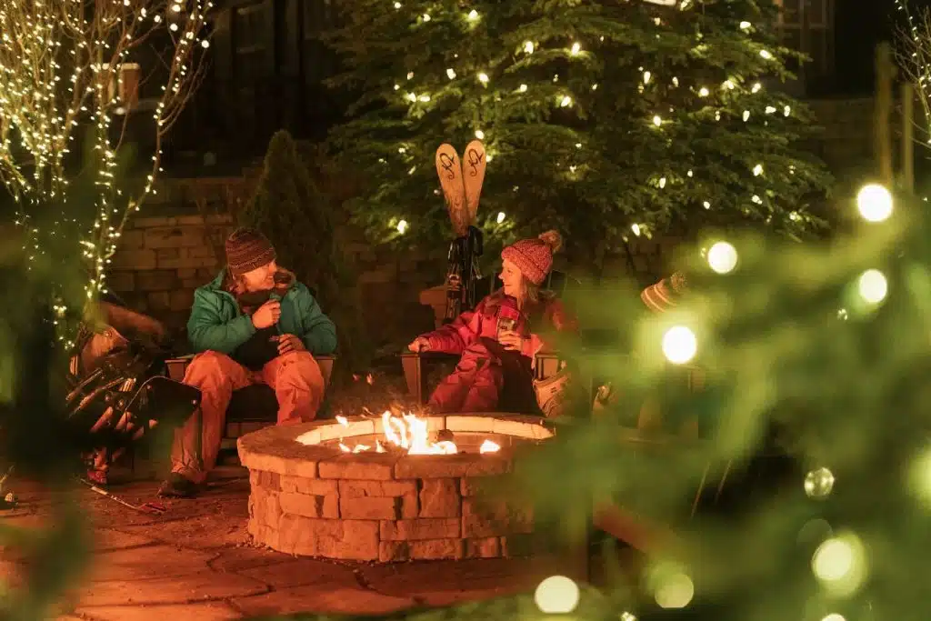 A family sits around an outdoor firepit at Beech Mountain Ski Resort.